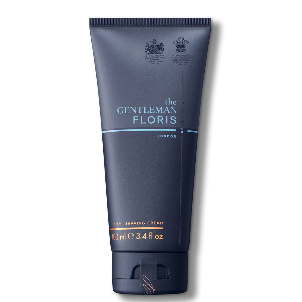 Das Bild zeigt eine marineblaue Rasiercremetube von „The Gentleman Floris London“ mit dem Markennamen in Weiß und einer hellblauen Linie darunter, sowie zwei königlichen Wappen, die Hoflieferantenauszeichnungen andeuten. Die Produktbezeichnung „No. 89 SHAVING CREAM“ und die Größe „100 ml“ sind ebenfalls vermerkt.