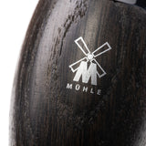 Detailaufnahme des MÜHLE-Logos auf dem hochwertigen Griff aus Mooreichenholz hebt die erstklassige Verarbeitung und das edle Design des Kosmo-Rasierpinsels hervor.
